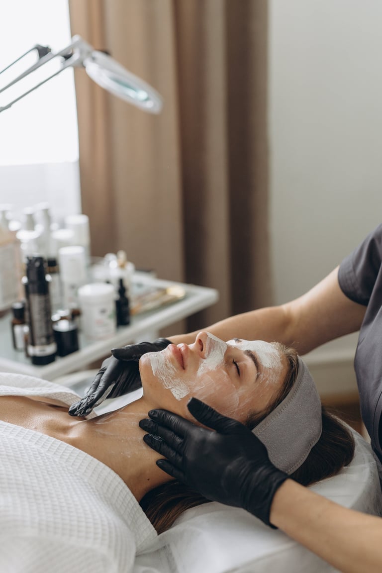 Close up of cosmetologist make face mask for woman client in saloon. Dermatology, beauty concept
