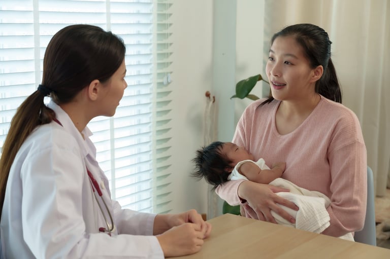 Pediatric doctor consulting smiling mother holding newborn baby