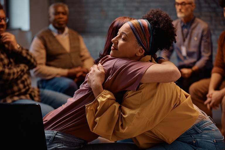 Group therapy participants hugging during mental health counseling