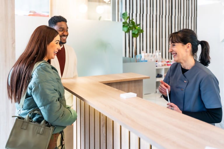 Happy couple communicating with the receptionist at a modern medical clinic