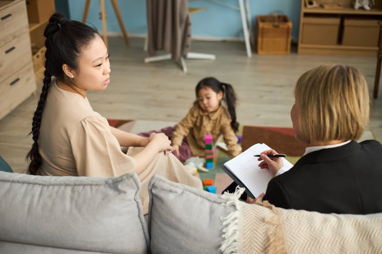 Family therapy session with therapist supporting mother and child at home
