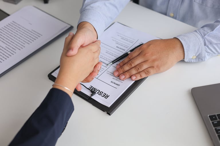 Professional handshake over resume after successful job interview and hiring